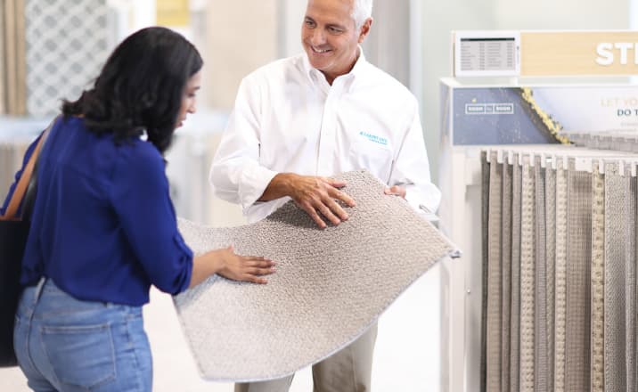 customer and sales person looking at carpet